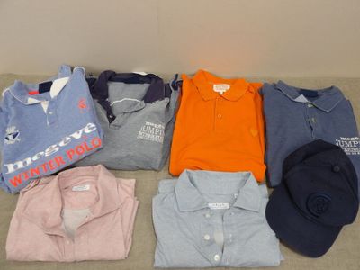 a lot of polo shirts and hats laid out on the floor