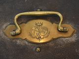 a brass handle that has a picture of a coat of arms on it