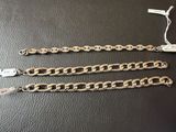 a pair of gold chain bracelets on a black surface