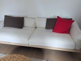 un canapé blanc orné de coussins rouges dans un salon