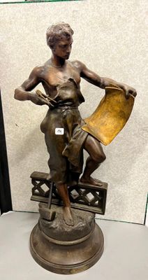 statue en bronze représentant une femme tenant un livre posé sur une table