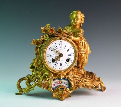 une horloge en or surmontée d'une statue