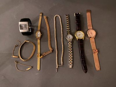 many different watches and bracelets laid out on a table