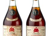 two bottles of liquor sitting next to each other on a white surface