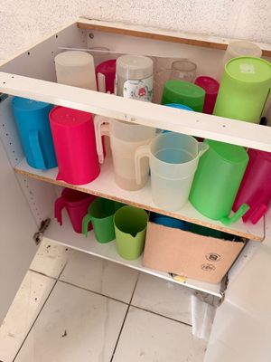 une étagère sur laquelle sont posées des tasses et des mugs dans la salle de bains