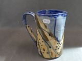 a blue and yellow coffee cup sitting on a table