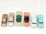 several toy cars are lined up in a row on a white surface