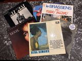 several records are sitting on a table with a black and white background