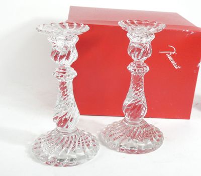 pair of clear glass candlesticks in front of a red box