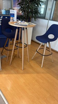 une petite table et des chaises dans une pièce où se trouve une plante