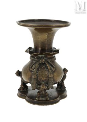 un vase en bronze posé sur un socle