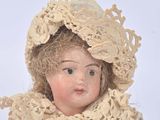 a doll that is wearing a hat and scarf