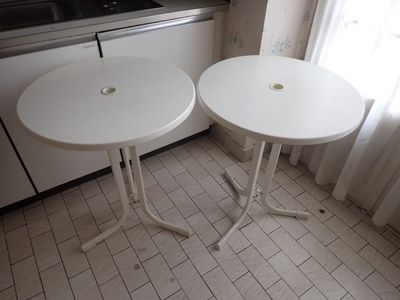 deux petites tables blanches dans une petite cuisine