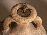 a vase that has a bird on top of it