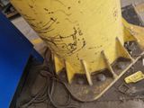 a yellow fire hydrant sitting on the ground next to a blue container