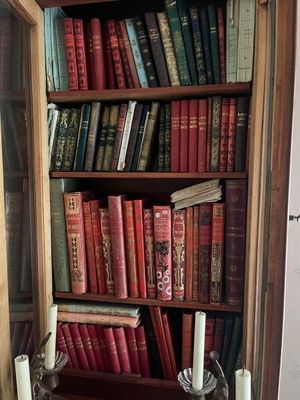 a book shelf with many books and candles in it