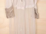 an image of a white dress hanging on a wooden wall
