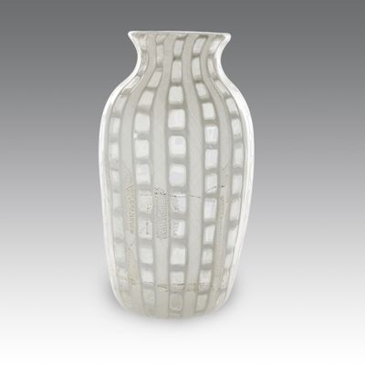 a white vase sitting on a table with a gray background
