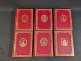 four red playing cards with gold designs on them sitting on a table
