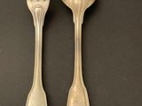 two spoons and a fork sitting on a table next to each other
