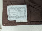 a brown blanket on the floor with a label on it