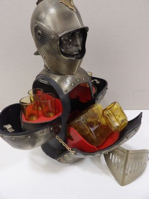 une statue représentant un chevalier tenant un plateau avec des boissons