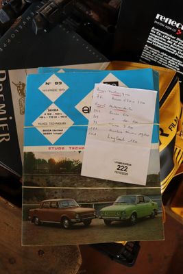 une voiture verte posée sur une table, à côté d'un livre