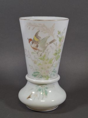 un vase blanc orné d'un oiseau, posé sur une table