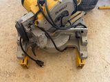 a corded circular saw sitting on the floor next to a tool bag