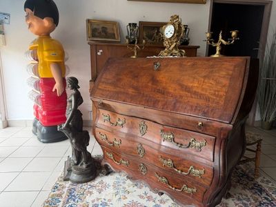 a statue of a boy and a desk in a room