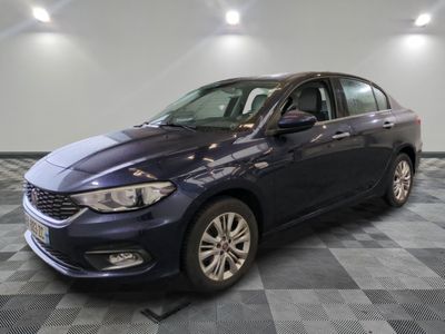La voiture bleue est garée sur un sol en carrelage à damier.