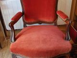 une chaise rouge posée devant une bibliothèque