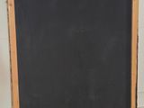 an image of a blackboard with a wooden frame on a wooden floor