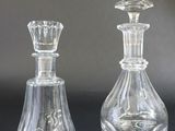 two clear glass vases sitting next to each other on a table