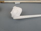 a pipe with a head on it next to a pipe holder