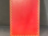 un livre rouge avec des bordures dorées et un liseré doré