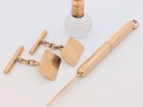 une photo représentant un stylo, des boutons de manchette et un flacon de parfum posés sur une table