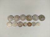 several different types of coins are arranged in a row on a white surface