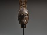 an image of a wooden sculpture of a head on a stand