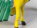 a figurine of a man riding on a yellow horse