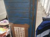 a blue door with a sign on it next to a pile of books