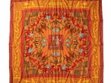 an orange and yellow scarf with a floral design on it