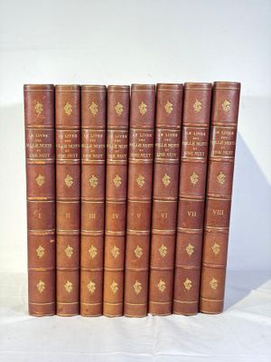 six vieux livres sont alignés sur une surface blanche