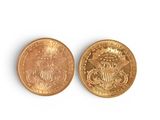 a close up of two gold coins on a white surface