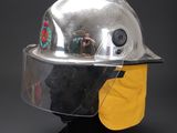 silver fireman ' s helmet with yellow visor and face shield
