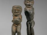 deux figurines sculptées représentant un homme et une femme tenant un bébé dans leurs bras