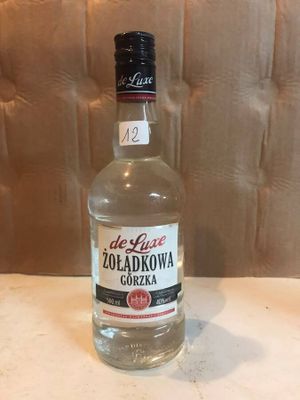 an empty bottle of vodka sitting on a table in front of a wall