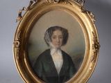portrait of a woman in a green coat and bonnet in a gold frame