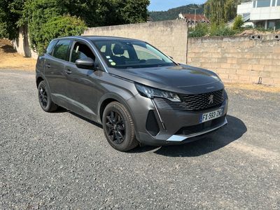 a grey car parked on the side of a road next to a brick wall