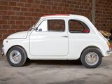 a small white car parked in front of a brick wall